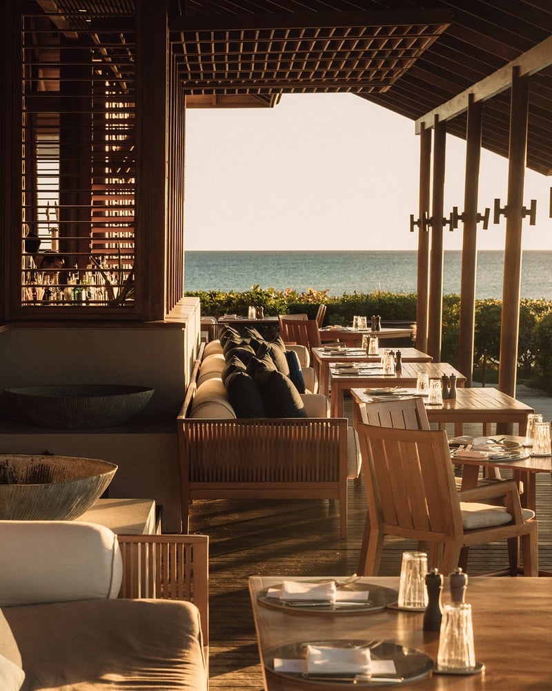 Tables and chairs face the ocean at Amanyara’s Beach Club.