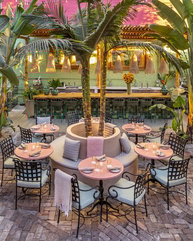 In Tacolina’s courtyard, white chairs surround pink bistro tables and palm trees add ambiance.