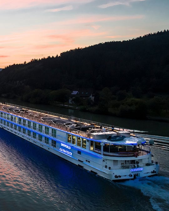 The cruise ship Beatrice slips down the Danube at sunset.