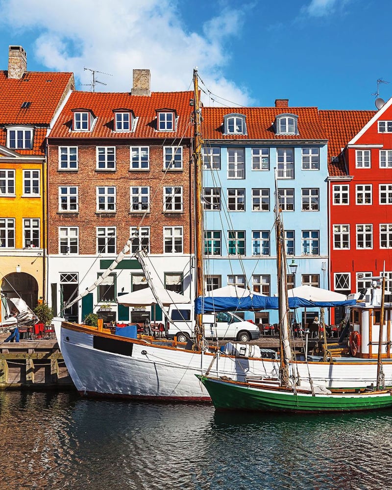 Colorful buildings and moored sailboats on Copenhagen’s waterfront.