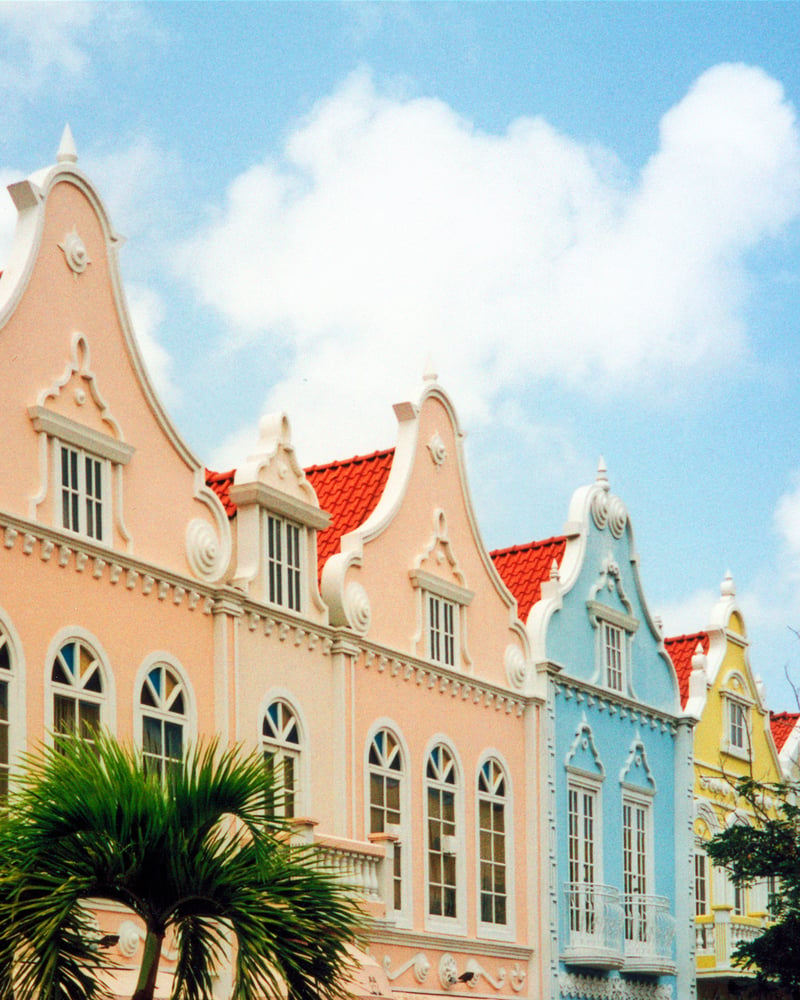 Pastel peach, blue, and yellow colonial buildings in Oranjestad, Aruba.