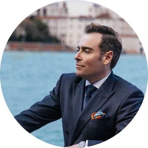 Étienne Petitpez, wearing a suit, sits in a speedboat looking out into the distance.