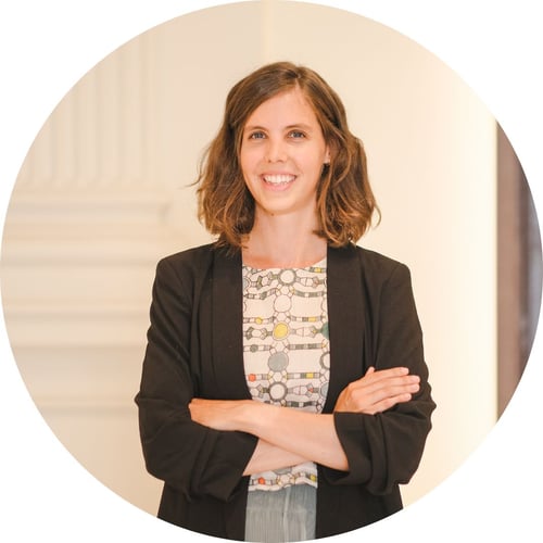 Tina Haselbacher, wearing a black blazer and printed shirt, smiles at the camera.