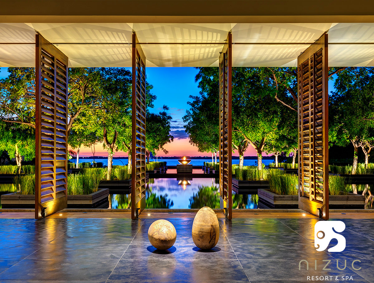 Image of a hotel lobby overlooking the water at sunset