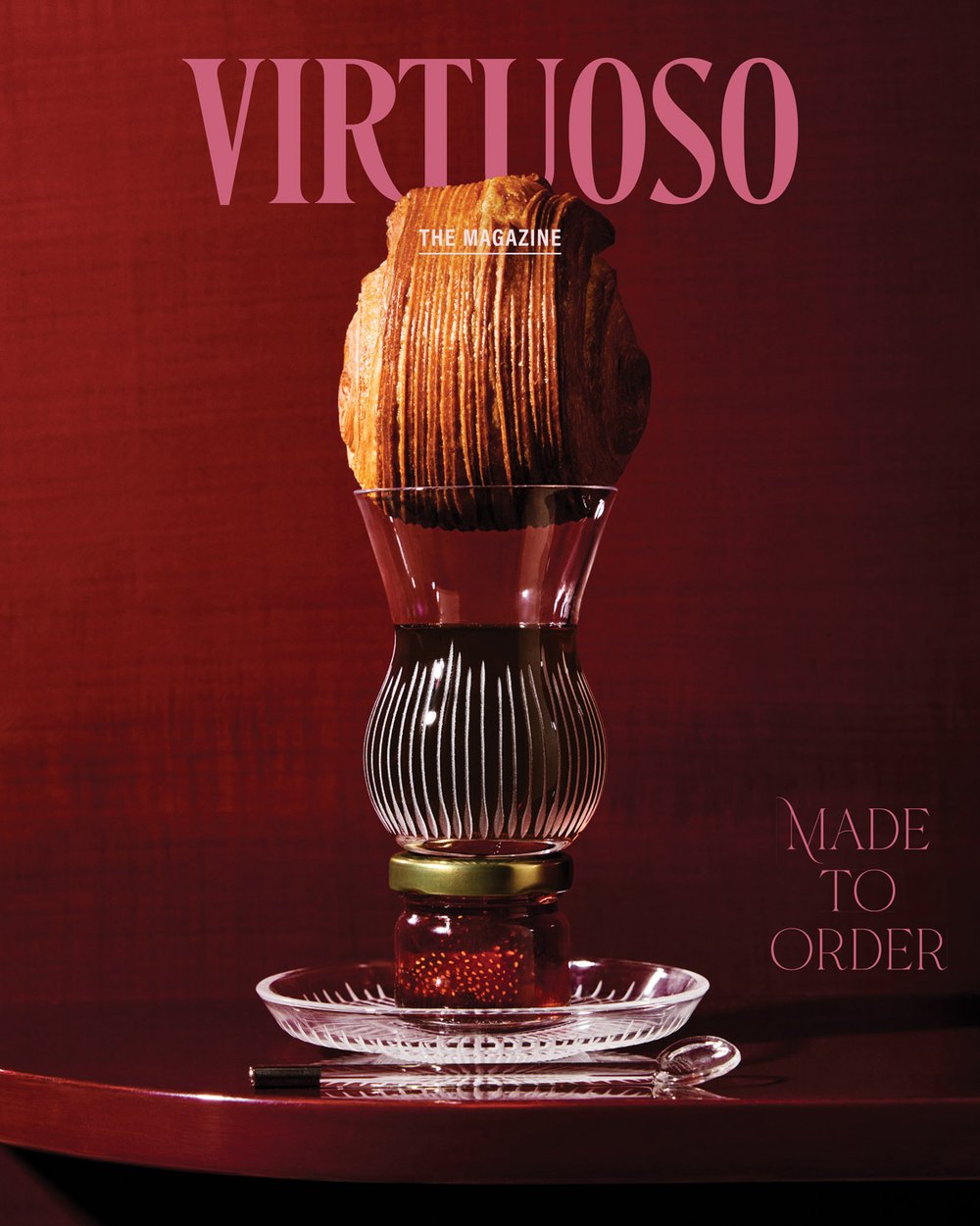 The November cover of Virtuoso, The Magazine shows a jam jar, Turkish tea, and a pastry stacked in a vertical tower in front of a deep red background.