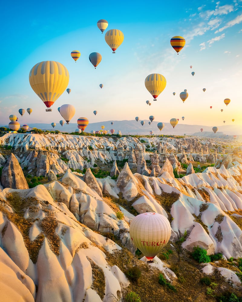 Dozens of hot-air balloons float above stone pillars in Turkey’s Cappadocia region.