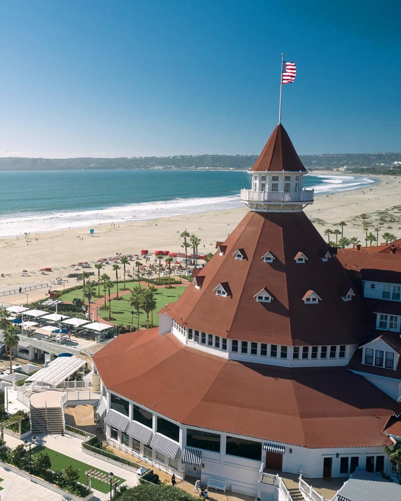 An overhead view of the Hotel del Coronado’s turret, swimming pool, and beach on Coronado Island.