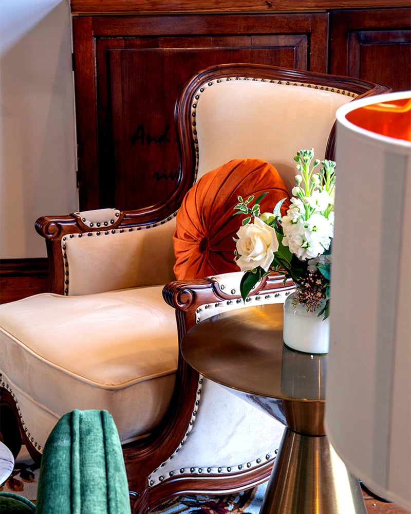 An interior scene at Islington Hotel shows a cream armchair with orange and teal decorations surrounding it.
