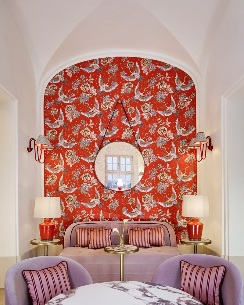 Red floral wallpaper and pink and red furnishings at Amalie, a patisserie at Hotel Taschenbergpalais Kempinski.