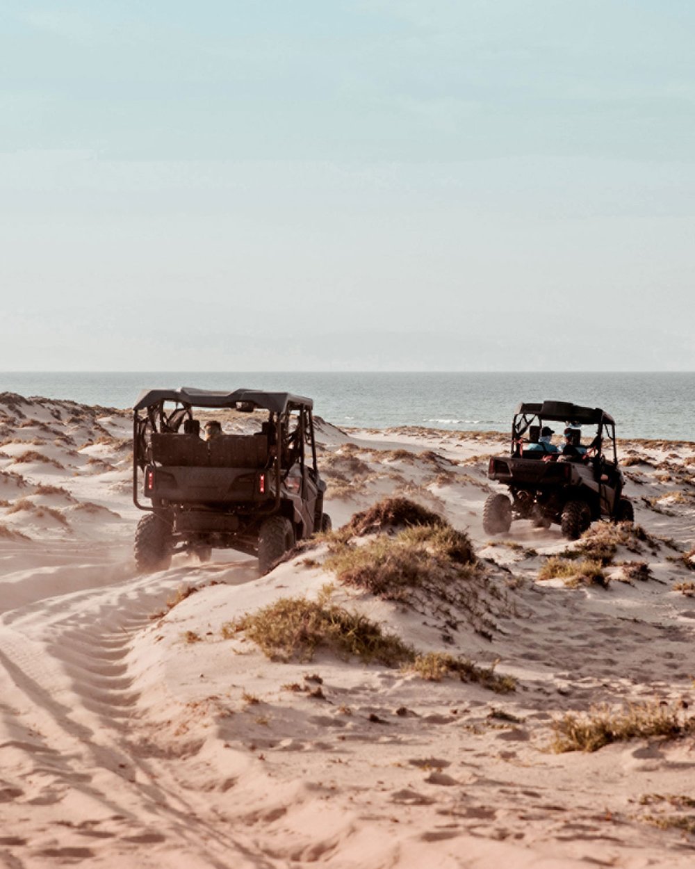 Two dune buggies drive on the beach in East Cape, Los Cabos, Mexico.