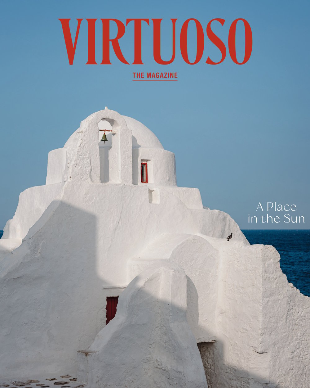 The March cover of Virtuoso, The Magazine shows a white church in Mykonos, Greece, photographed against a blue sky. The cover line reads “A place in the sun.”
