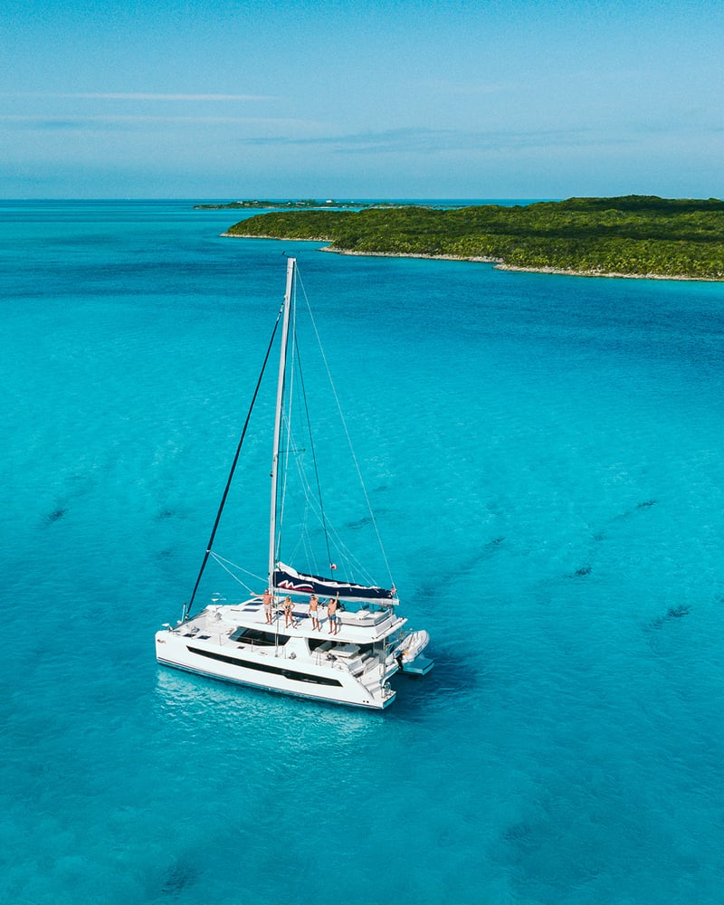 An overhead view of a Moorings catamaran at sea near a Caribbean island.
