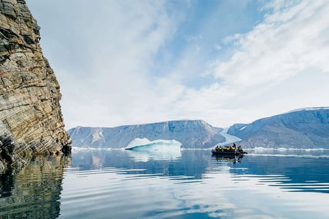 A zodiac boat sail on calm sea in Greenland.