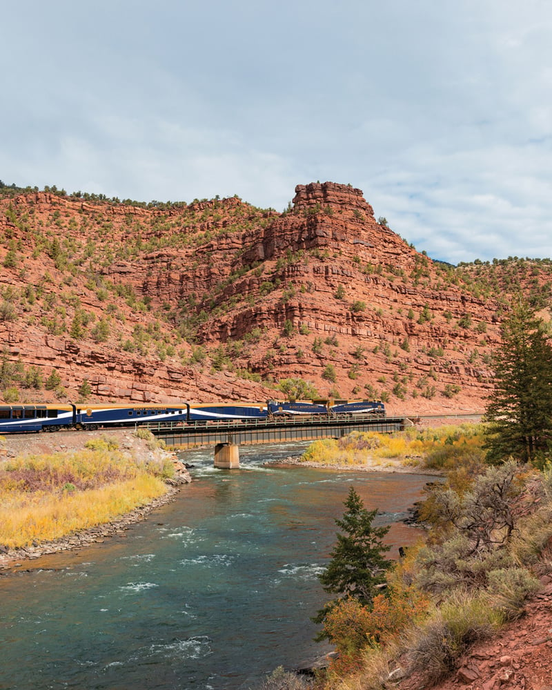 The Rocky Mountaineer train rides over a river in Utah’s Red Canyon.