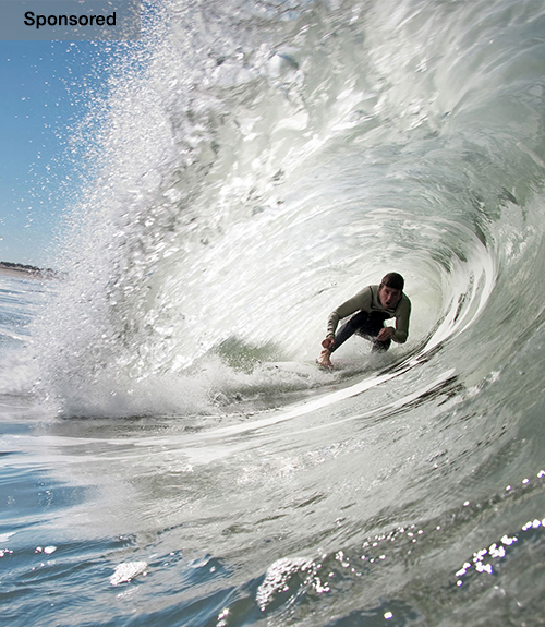 A surfer rides a barrel wave in Portugal.