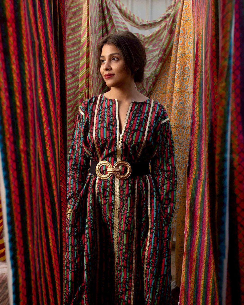Shaivyya Gupta stands among drying sheets of block-printed textiles.