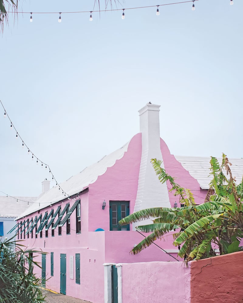 A light-pink building in Saint George’s Parish, with a white roof and teal windows and doors.