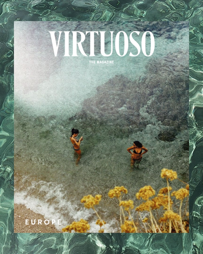 On the May cover of Virtuoso, The Magazine, two women seen from overhead stand in the water off the coast of Sicily.