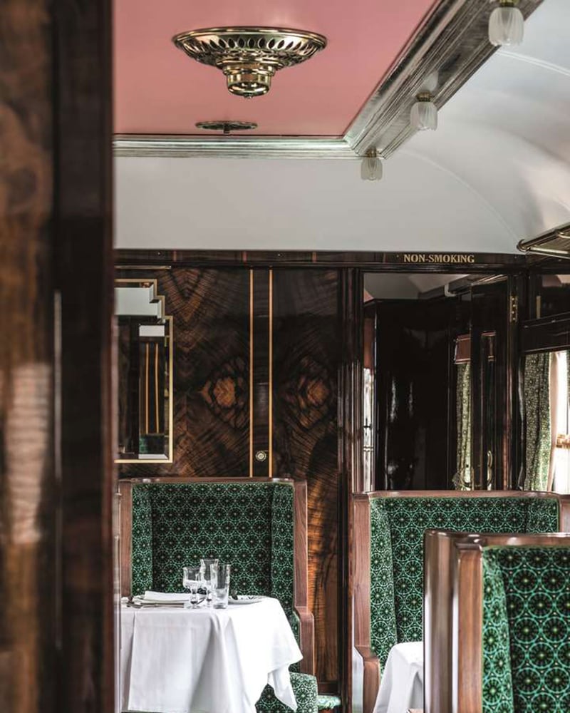 Green velvet chairs and white linens in the dining car designed by Wes Anderson aboard the Venice Simplon-Orient-Express.